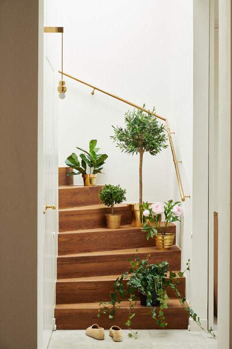 Bilden visar konstväxter i en trappa. Konstgjorda växter och kontblommor finns i många olika varianter online.